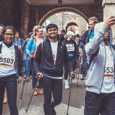 Nordic-Walking-Gruppe mit Stöcken unterwegs durch den Torbogen beim Stolberger Schloss-Lauf.